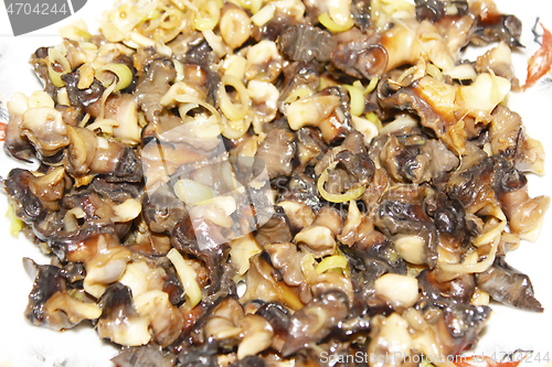 Image of Closeup of eating the fried snails with stalks lemon grass 