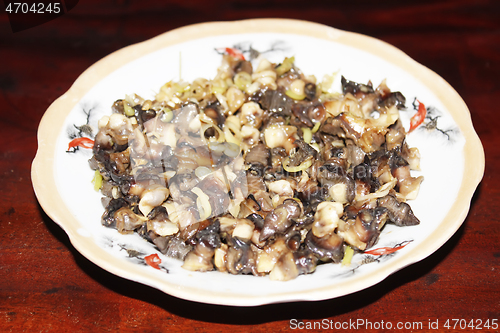 Image of Closeup of eating the fried snails with stalks lemon grass 