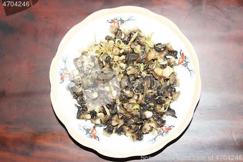 Image of Closeup of eating the fried snails with stalks lemon grass 