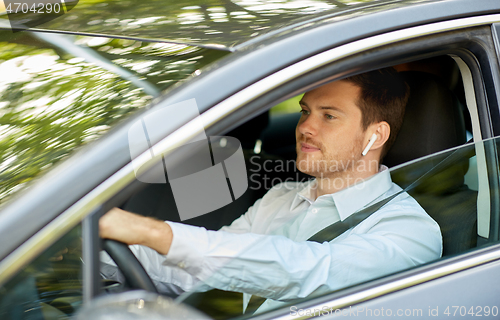 Image of man or driver with wireless earphones driving car