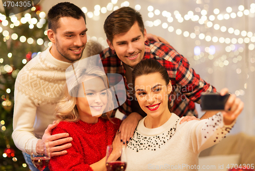 Image of friends taking selfie at christmas dinner