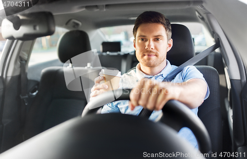 Image of man or driver with takeaway coffee cup driving car