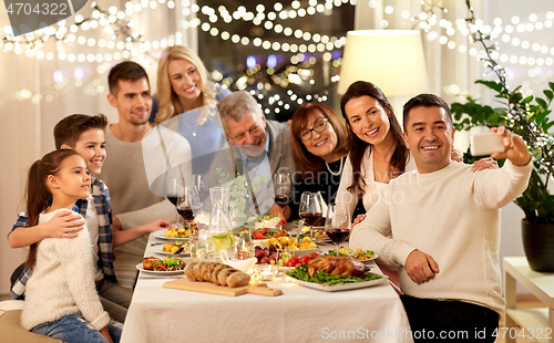 Image of family having dinner party and taking selfie