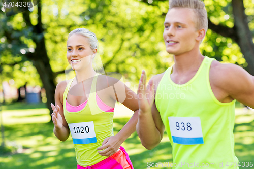 Image of happy couple of sportsmen racing wit badge numbers