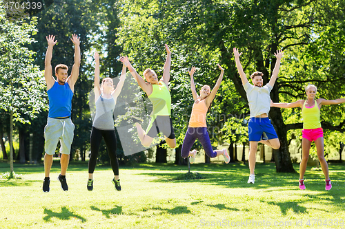 Image of group of happy friends jumping high at park