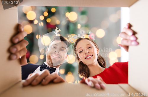 Image of happy couple opening christmas gift box