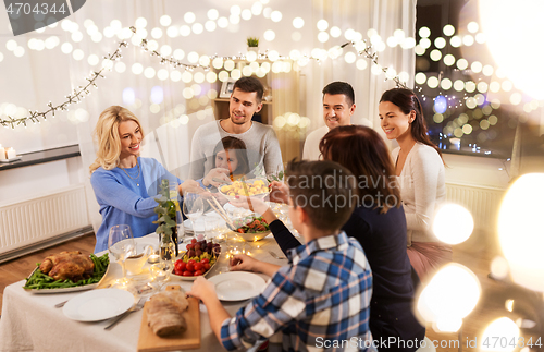 Image of happy family having dinner party at home