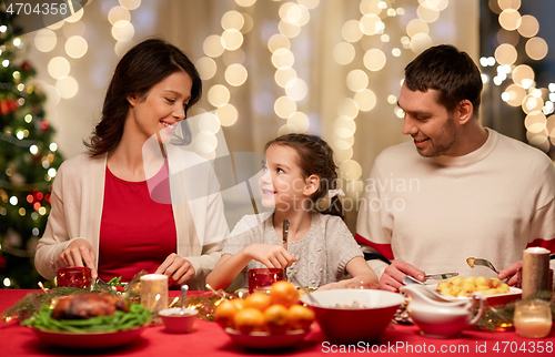 Image of happy family having christmas dinner at home