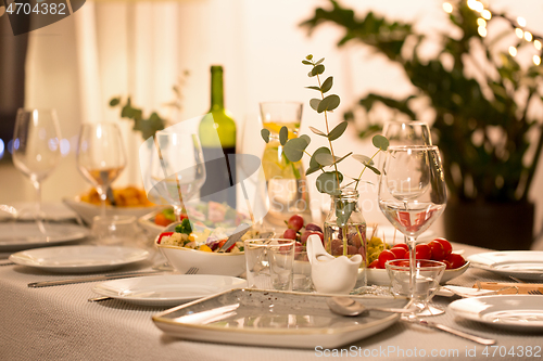 Image of table served with plates, wine glasses and food