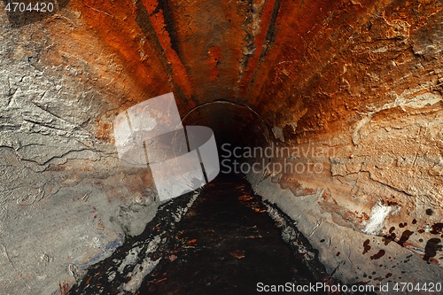 Image of Large sewage tunnel with filth flowing out