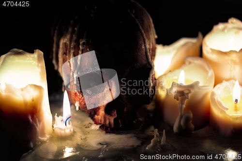 Image of Human skull against dark background in candle light closeup