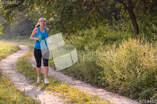 Image of woman jogging along a country road