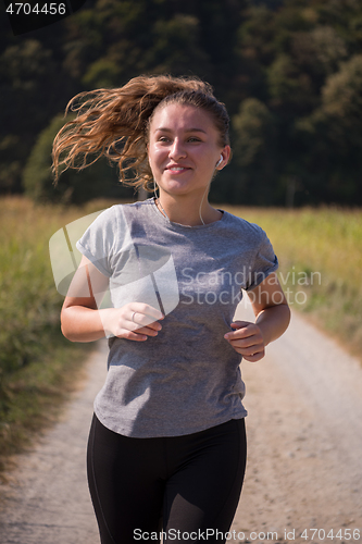 Image of woman jogging along a country road