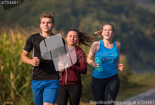 Image of young people jogging on country road