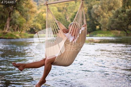 Image of blonde woman resting on hammock