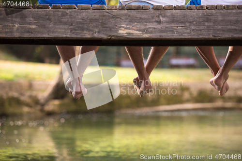 Image of people sitting at wooden bridge