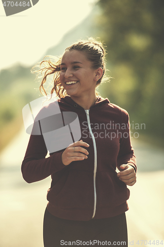 Image of woman jogging along a country road