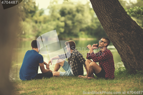 Image of men sitting on the bank of the river