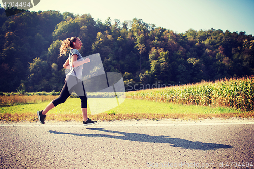 Image of woman jogging along a country road