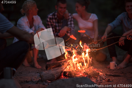 Image of young friends relaxing around campfire