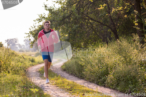 Image of man jogging along a country road