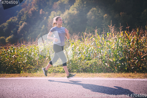 Image of woman jogging along a country road