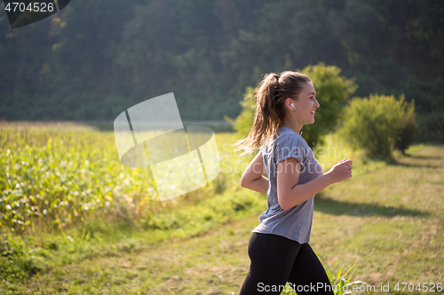 Image of woman jogging along a country road