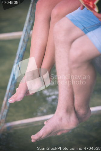 Image of people sitting at wooden bridge