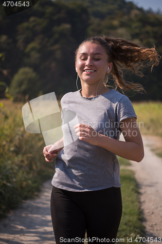 Image of woman jogging along a country road