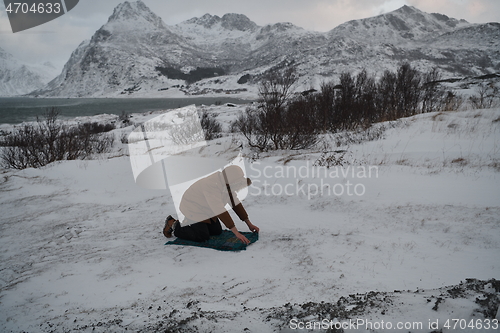 Image of Muslim traveler praying in cold snowy winter day