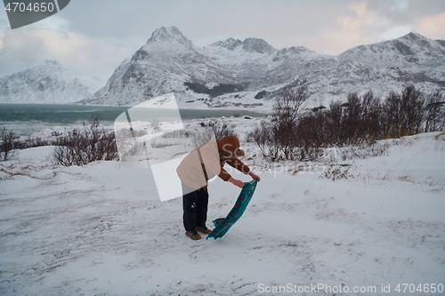 Image of Muslim traveler praying in cold snowy winter day