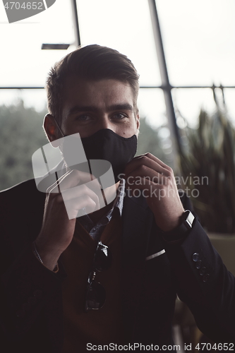 Image of business man wearing protective face mask at luxury office