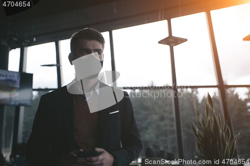 Image of business man wearing protective face mask at luxury office