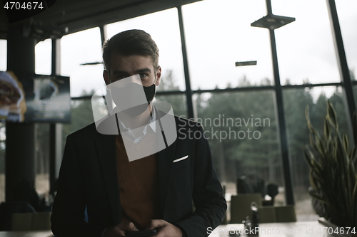 Image of business man wearing protective face mask at luxury office