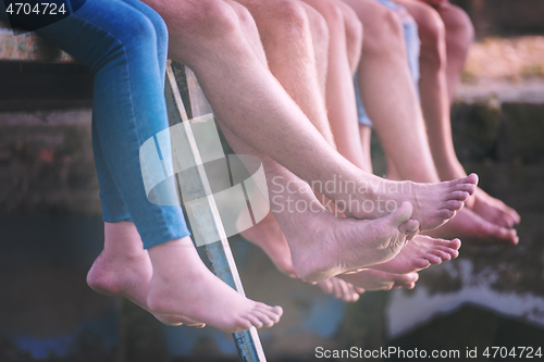 Image of people sitting at wooden bridge