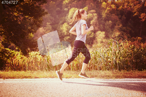 Image of woman jogging along a country road