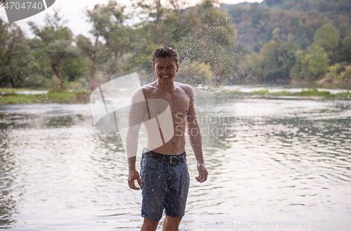 Image of man with a bare torso splashing water