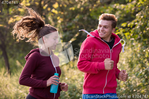 Image of young couple jogging along a country road