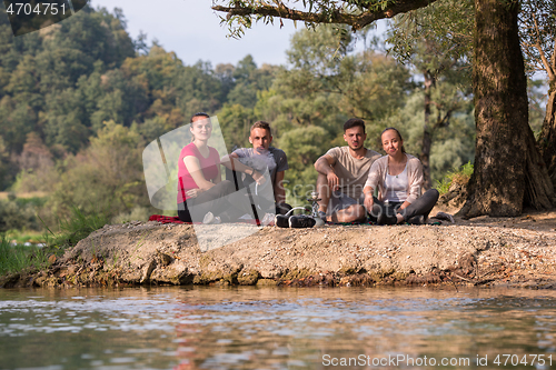 Image of friends smoking hookah on the river bank