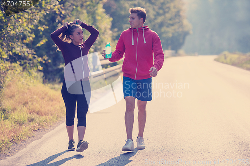 Image of young couple jogging along a country road