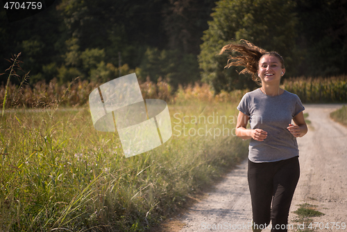 Image of woman jogging along a country road