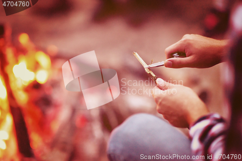 Image of young friends relaxing around campfire