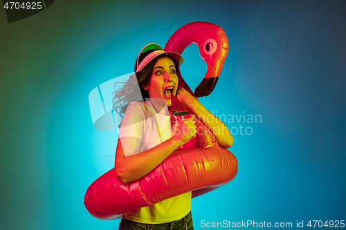 Image of Happy young woman standing and smiling against blue background