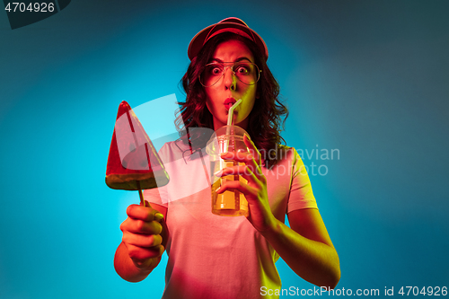 Image of Happy young woman standing and smiling against blue background