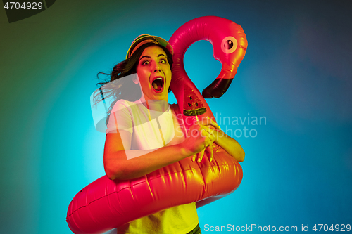 Image of Happy young woman standing and smiling against blue background