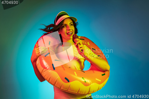 Image of Happy young woman standing and smiling against blue background