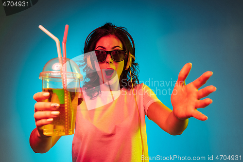 Image of Happy young woman standing and smiling against blue background