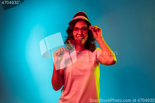 Image of Happy young woman standing and smiling against blue background