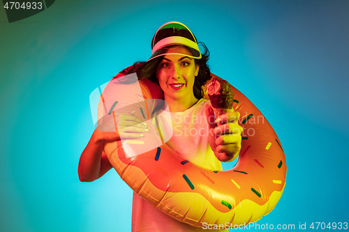 Image of Happy young woman standing and smiling against blue background