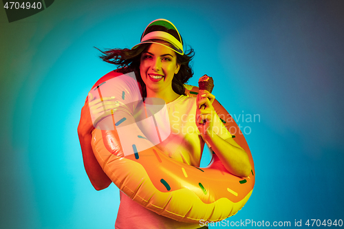 Image of Happy young woman standing and smiling against blue background